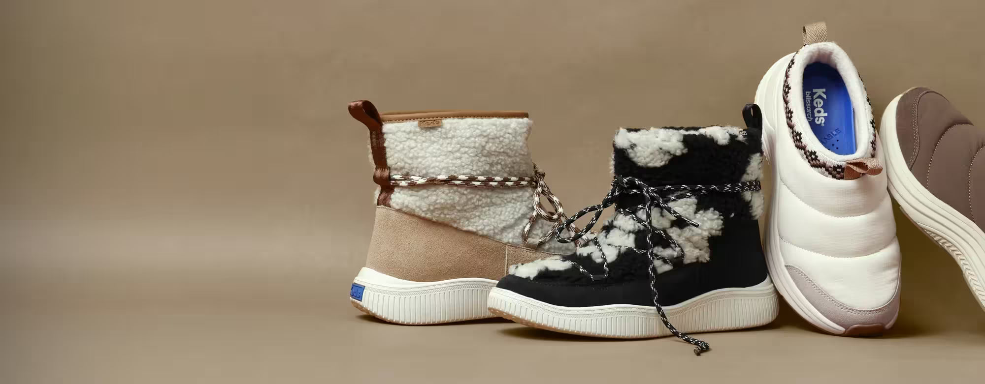 Cozy boots and clogs on a sand-colored background