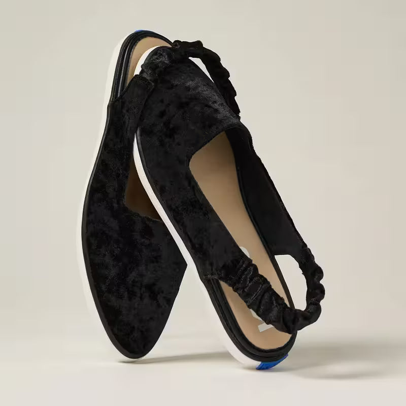 A pair of the Point Toe Crushed Velvet Slingbacks in black with the scrunchy slingback strap around the toe of the other.