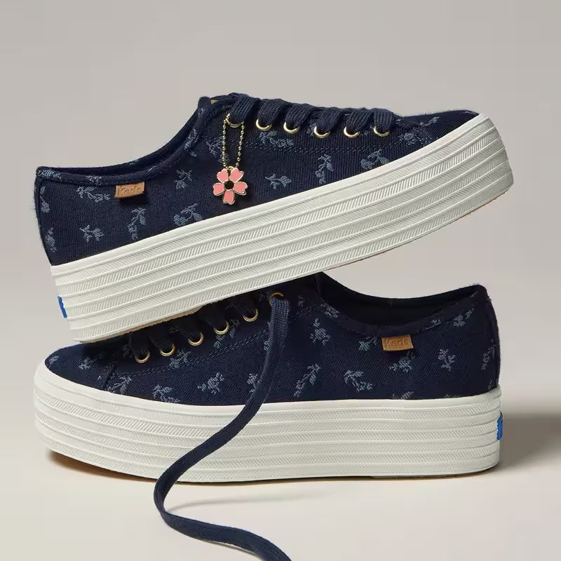 A pair of the Triple Up Chambray Floral Jacquard Charm Lace-Up in blue with one stacked on top of the other.